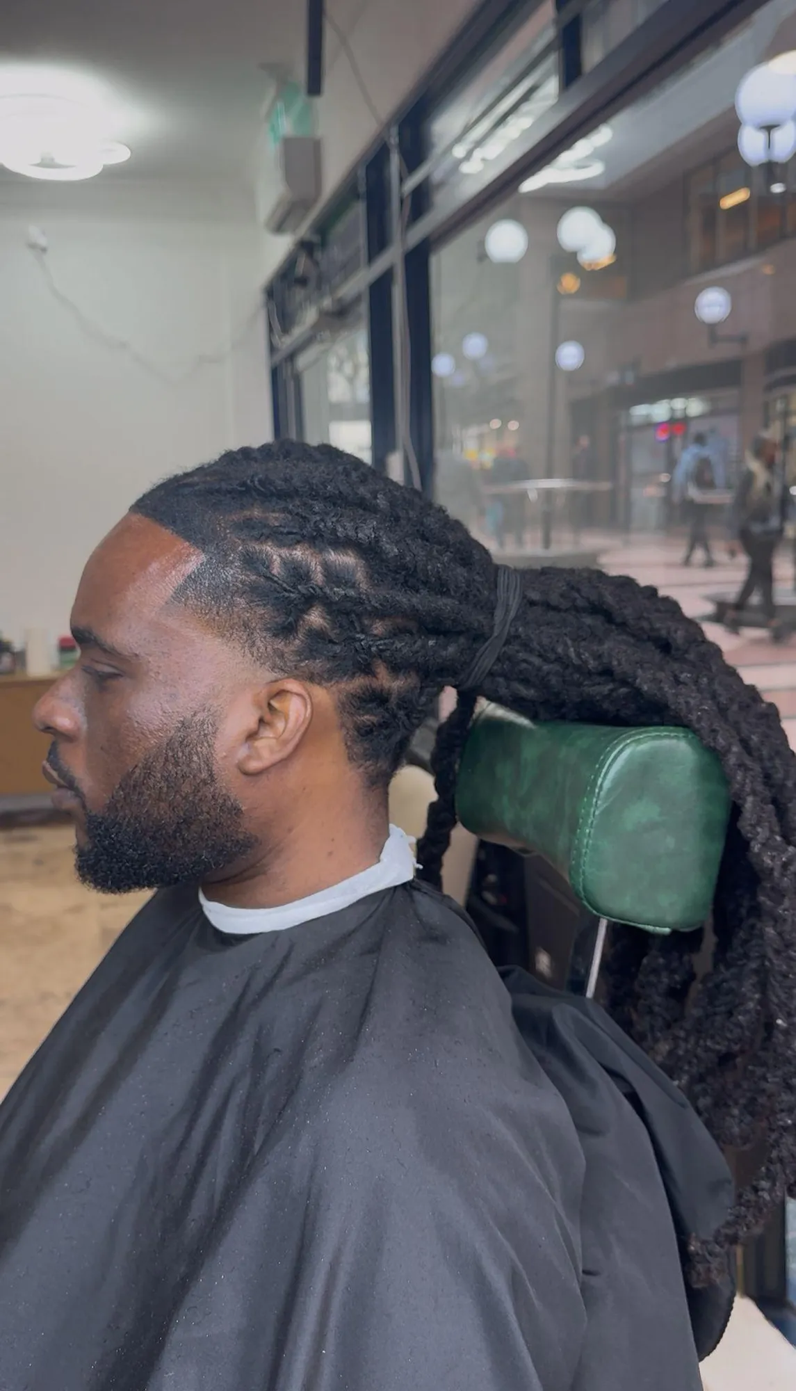 Men's long locs styled back with a fresh line-up